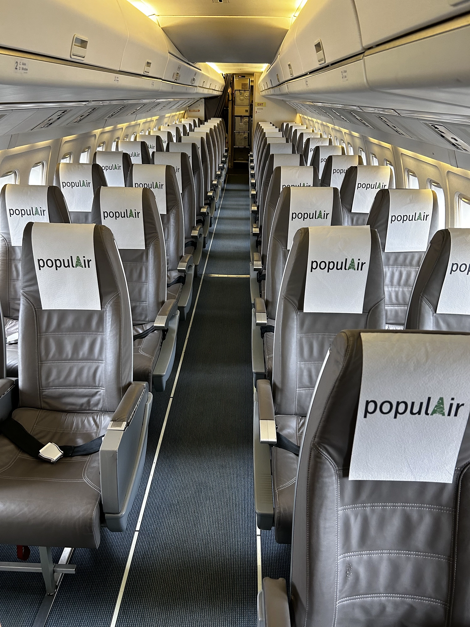 Fokker 50 interiör - rena grå säten, blågrå mittgång och ljus, luftig känsla